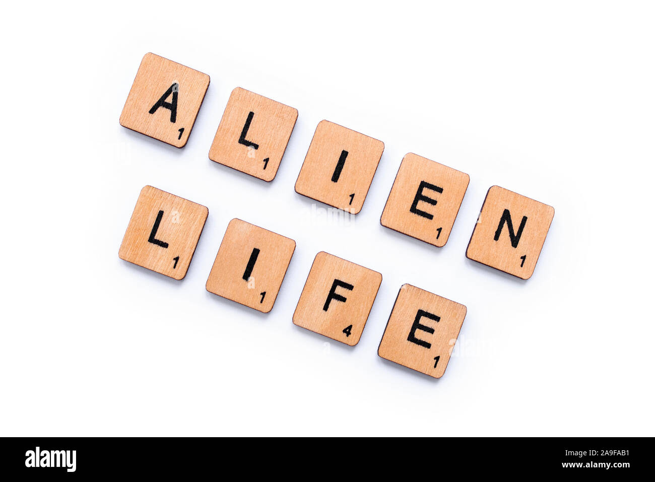 London, UK - June 12th 2019: The phrase ALIEN LIFE, spelt with wooden letter tiles over a white background. Stock Photo