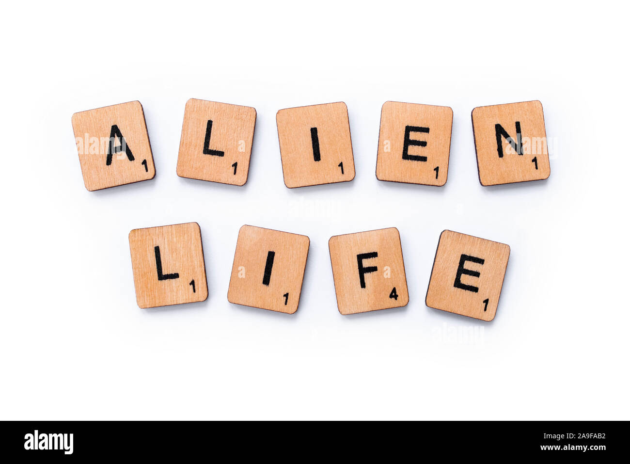 London, UK - June 12th 2019: The phrase ALIEN LIFE, spelt with wooden letter tiles over a white background. Stock Photo