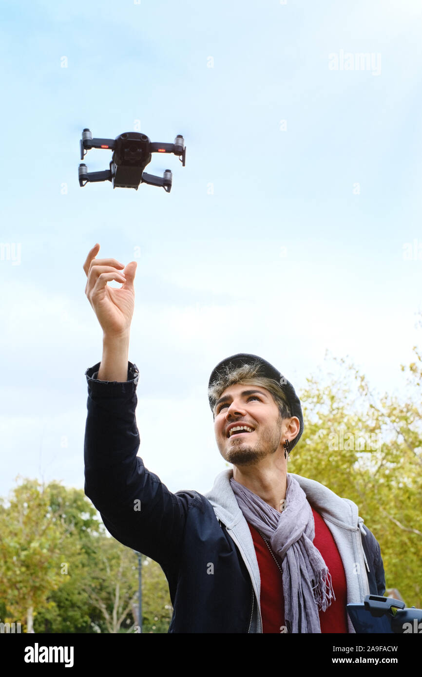 Young Man With Remote Control Landing Drone In His Hands Stock Photo