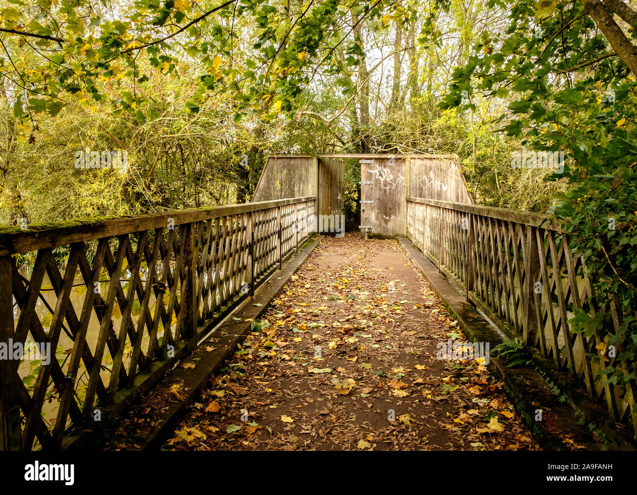 A footbridge on the River Cherwell flowing through the Oxford University Parks connecting to the Mesopotamia Walk Stock Photo