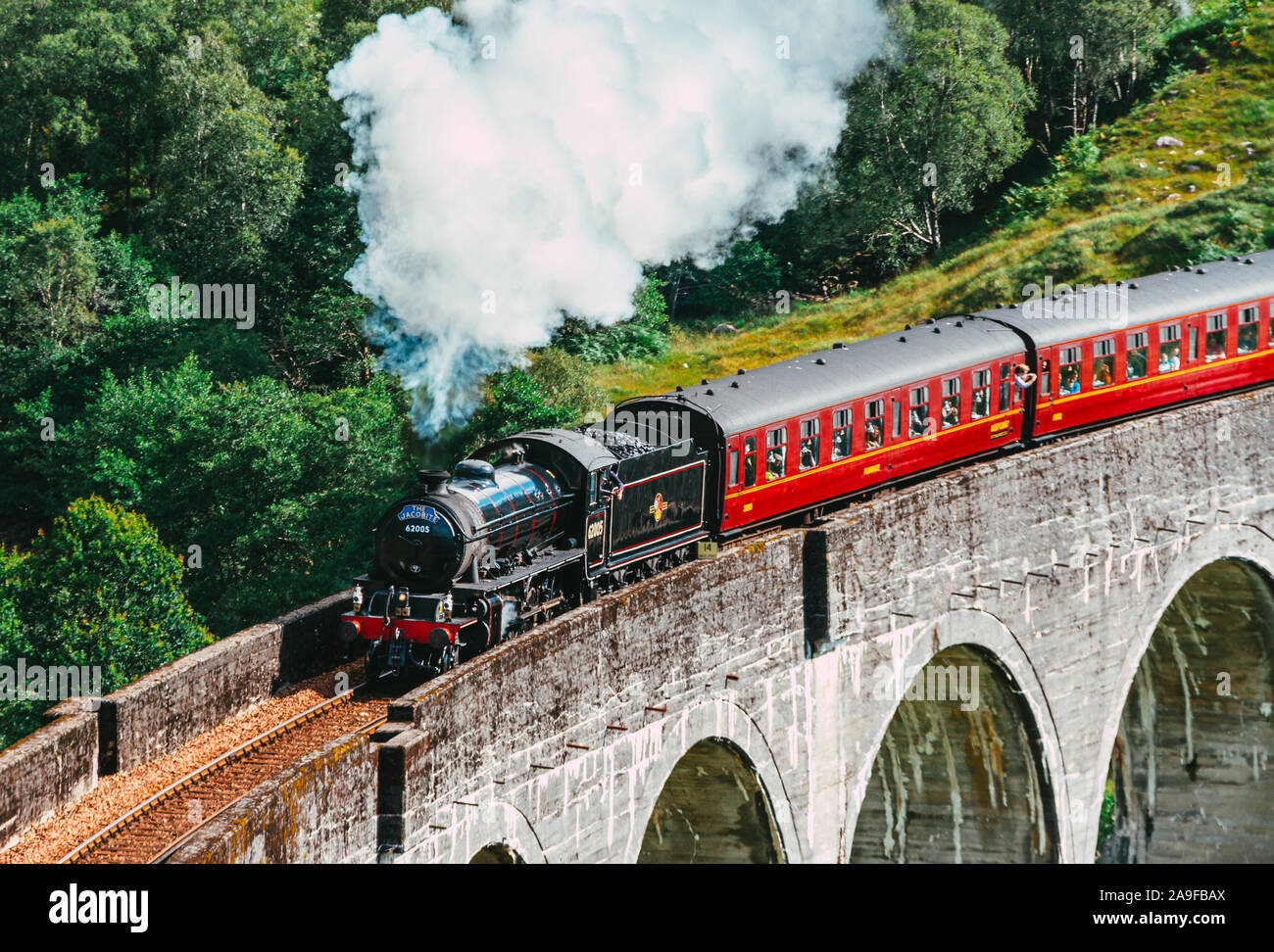 The Jacobite Steam Train, also known as the Hogwarts train as it was used in the Harry Potter movie franchise, traveling along the Glenfinnan Viaduct Stock Photo