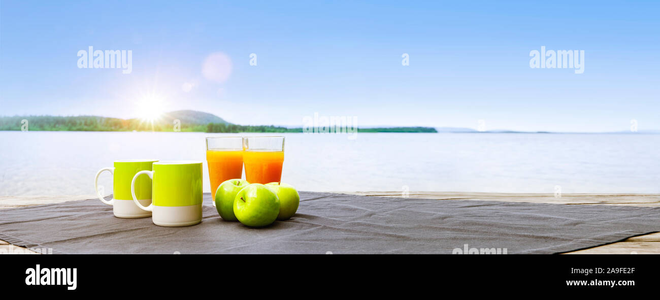 Breakfast on the lake with apples and orange juice Stock Photo
