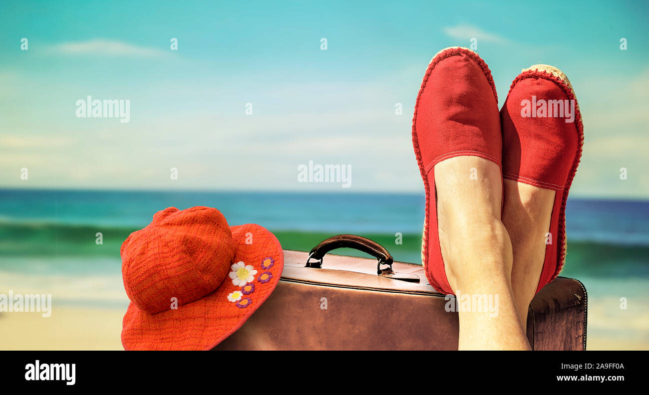 Legs with red cloth shoes in front of beach and sea Stock Photo