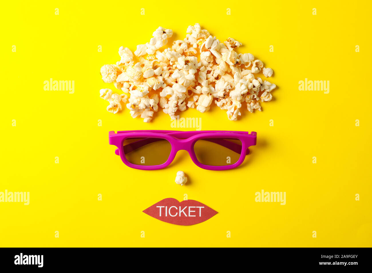 Flat lay composition with movie watching accessories on yellow