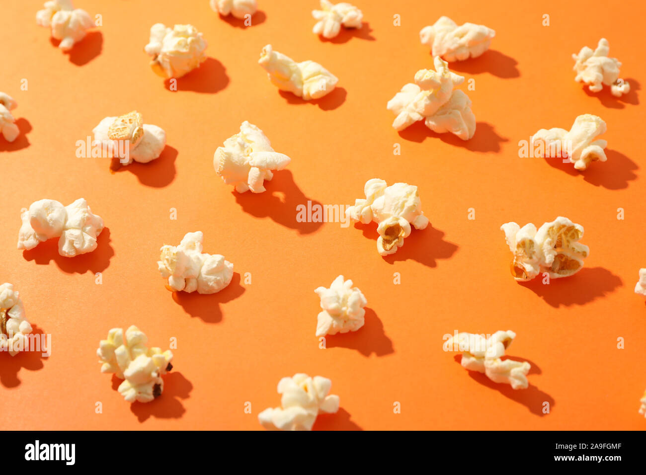 Flat lay composition with popcorn on orange background, closeup Stock Photo