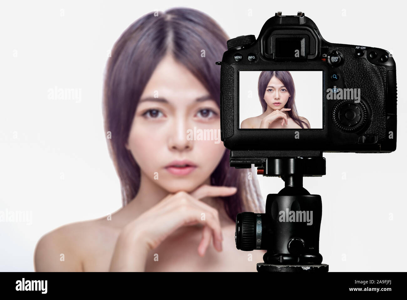 Asian American beauty vlogger creating content for social media vlog, behind camera shot Stock Photo