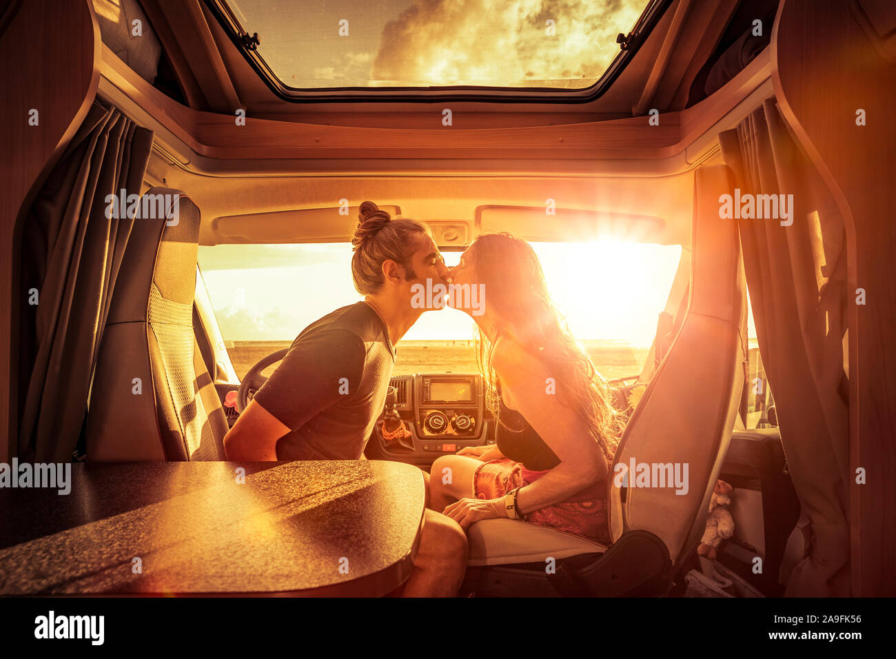 Couple in camper at sunset in romantic mood Stock Photo