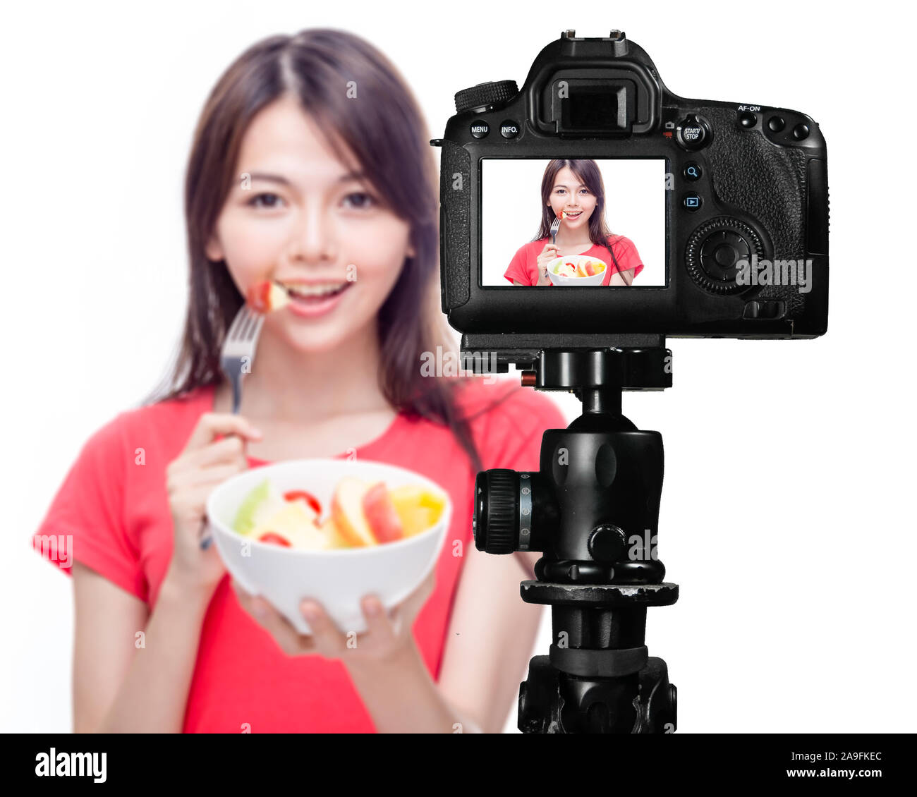 Asian food vlogger with fruit salad behind camera, social media