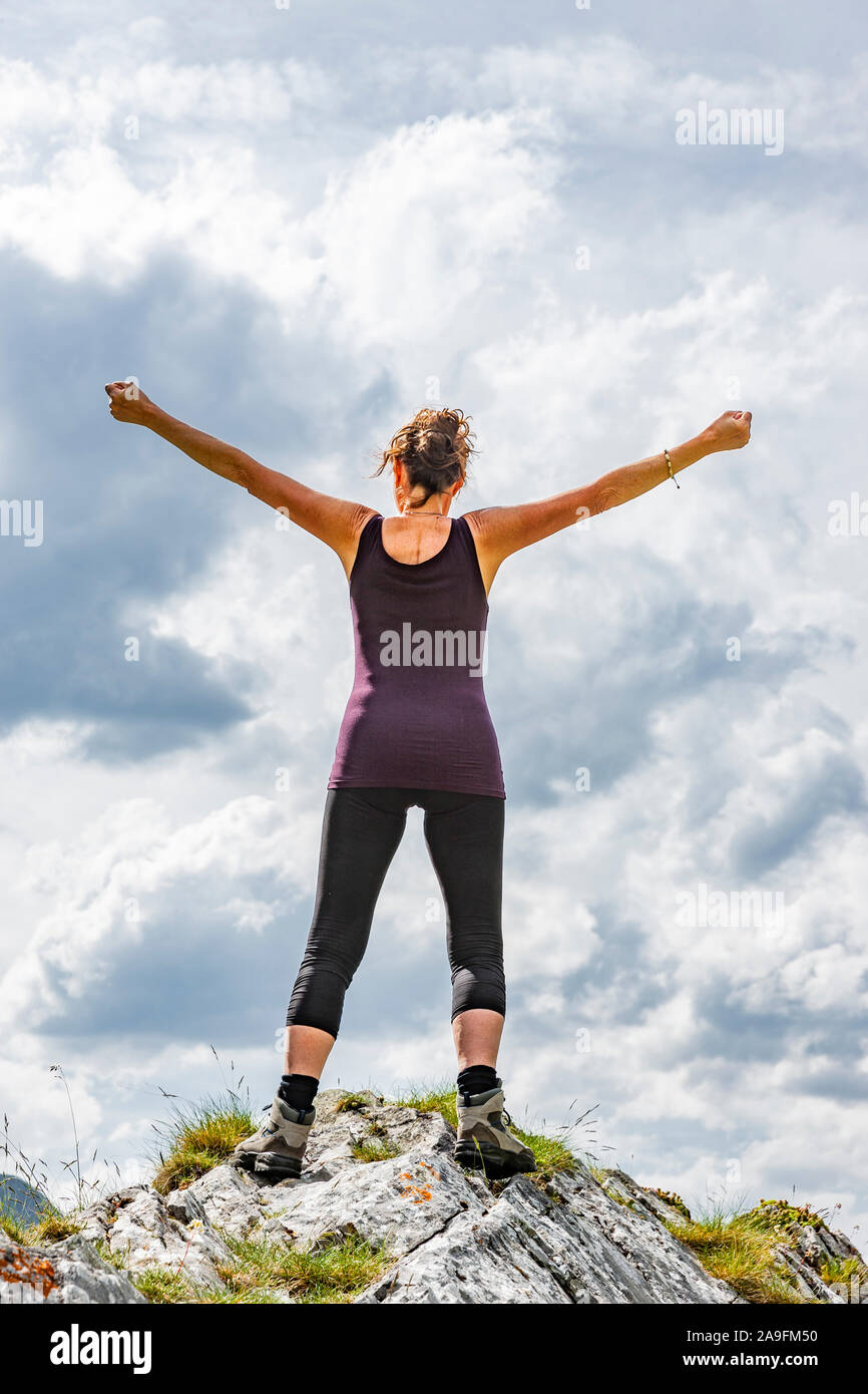 Female silhouette in victory pose on a pinnacle Stock Photo