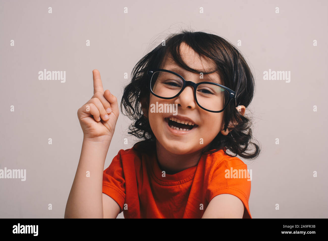 Smiling Little boy raising his hand isolated background Stock Photo - Alamy