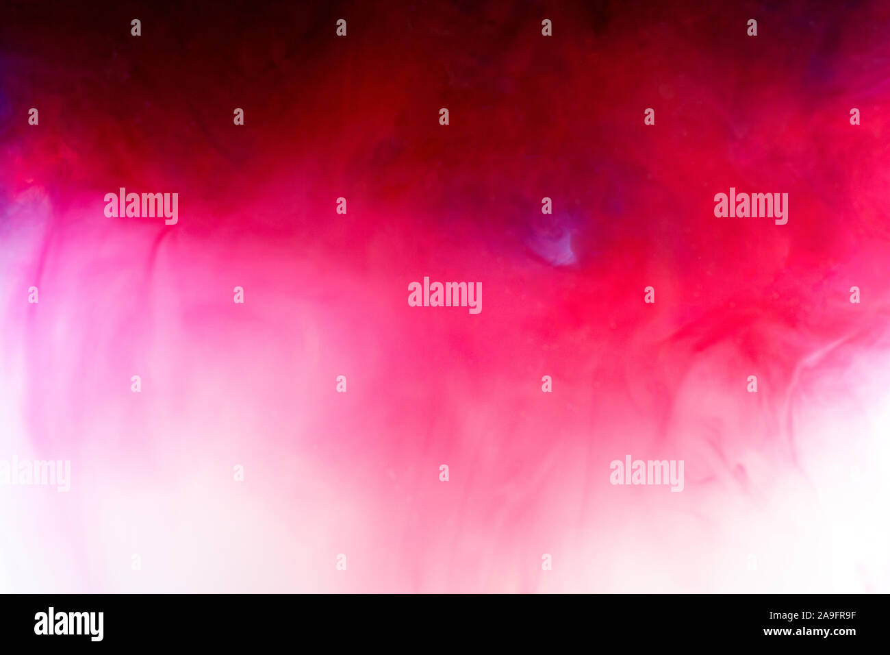 Background with red ink and soft pink mixing in the liquid Stock Photo