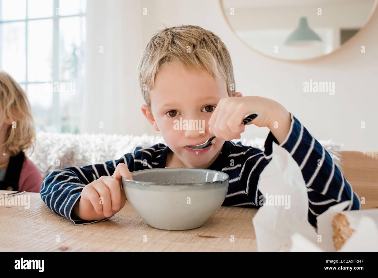 young boy eating breakfast at home before school Stock Photo