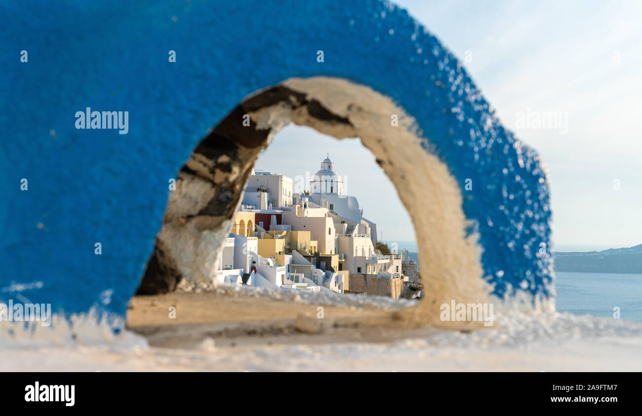 Picturesque view of a Fira village through a blue arc on the wall. Stock Photo