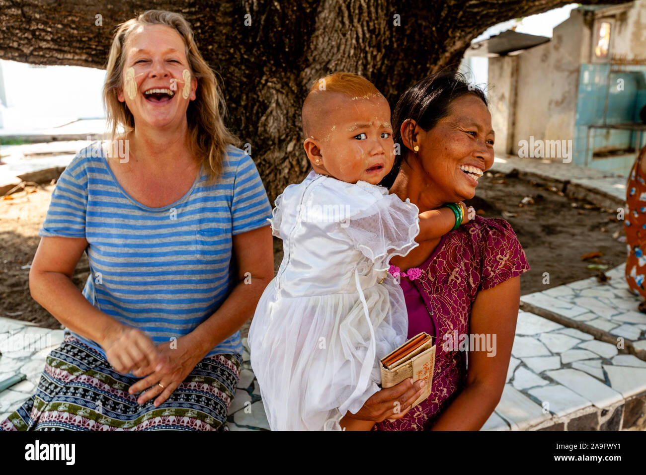 A Burmese Child Is Frightened At The Sight Of A Caucasian Female Tourist The Kuthodaw Pagoda, Mandalay, Myanmar. Stock Photo