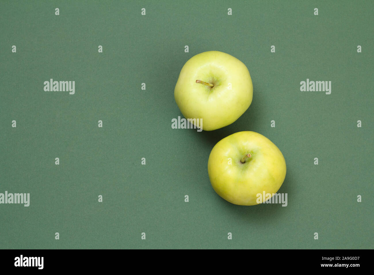 Two apples on green background with copy space. Top view. Stock Photo
