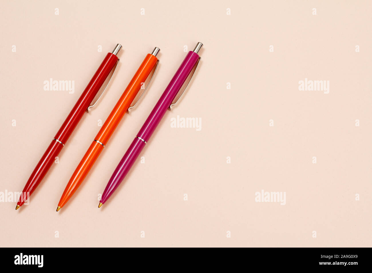 Three pens on a beige background. Top view with copy space. Stock Photo