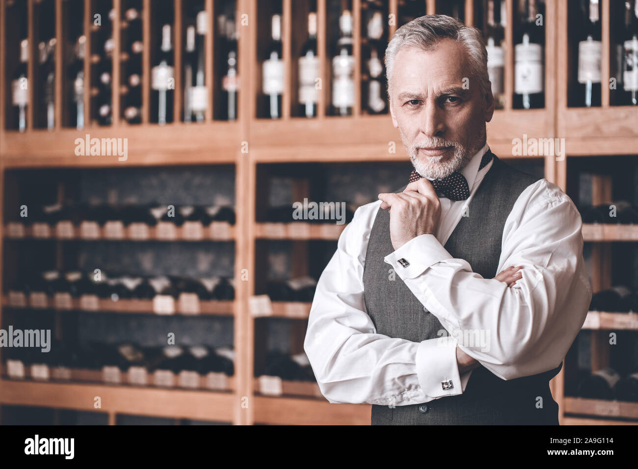 Sommelier Concept. Senior man standing touching chin smiling confident Stock Photo