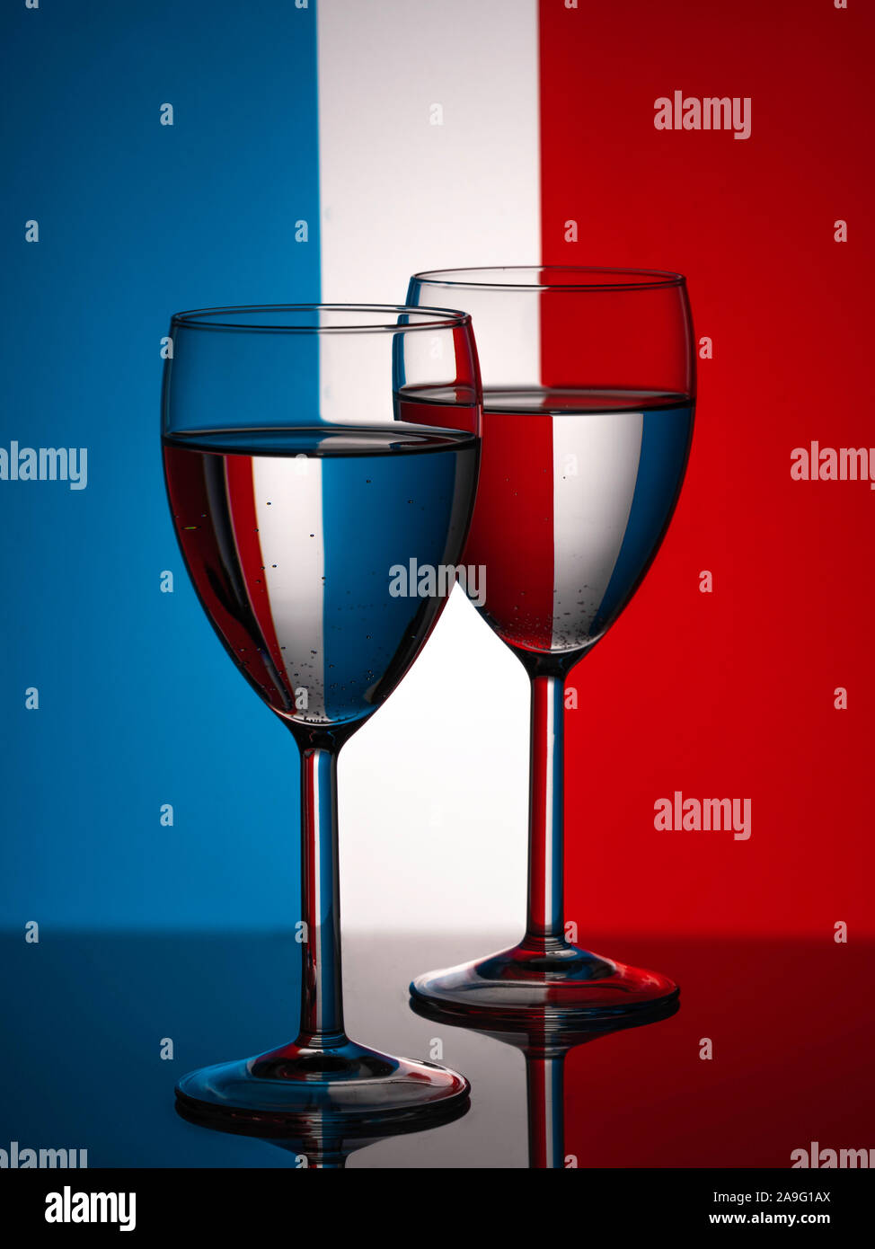 Two wine glasses silhouette full on french flag background. Alcohol beverage. French wine concept. Flag of France Stock Photo