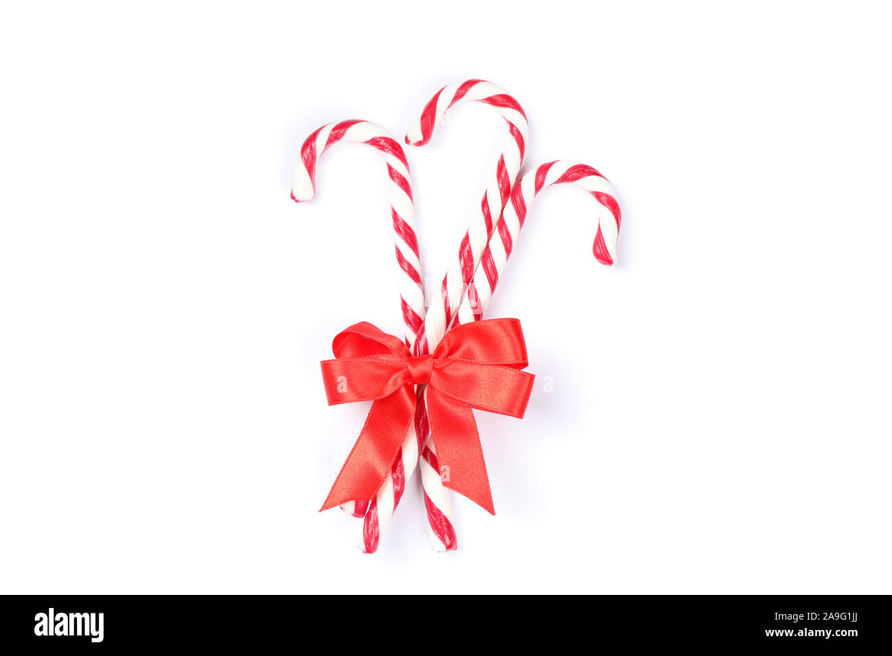 Sweet candy canes with bow isolated on white background Stock Photo