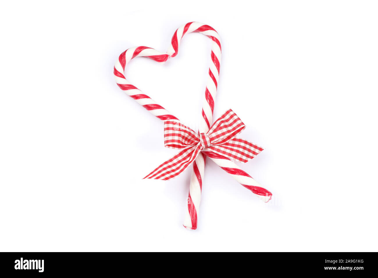 Sweet candy canes with bow isolated on white background Stock Photo