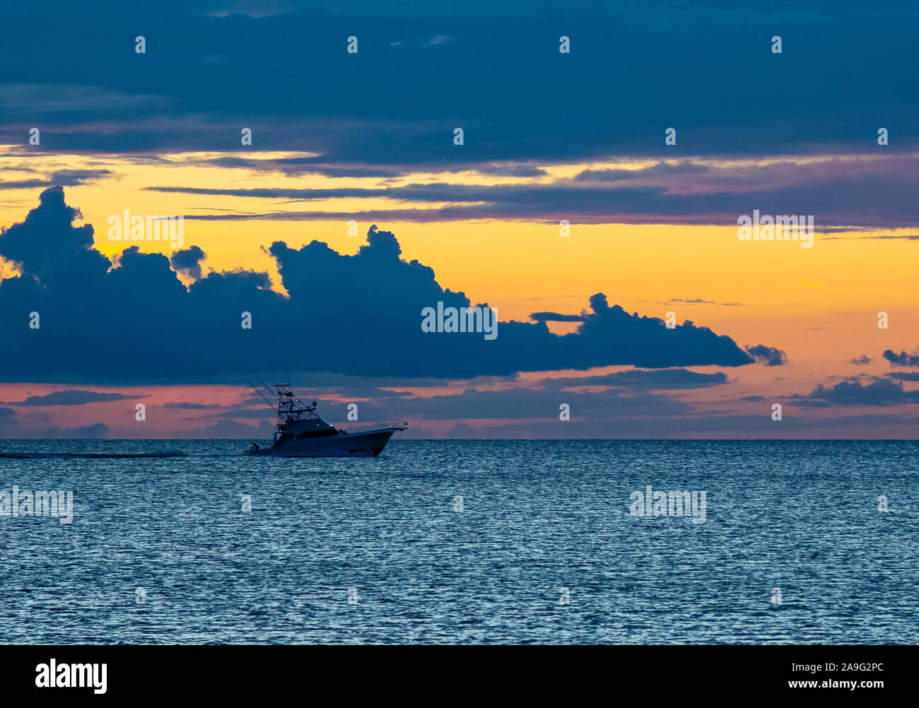 Boat in Gulf of Mexico silhoutted against a sunset sky off Venice Florida Stock Photo