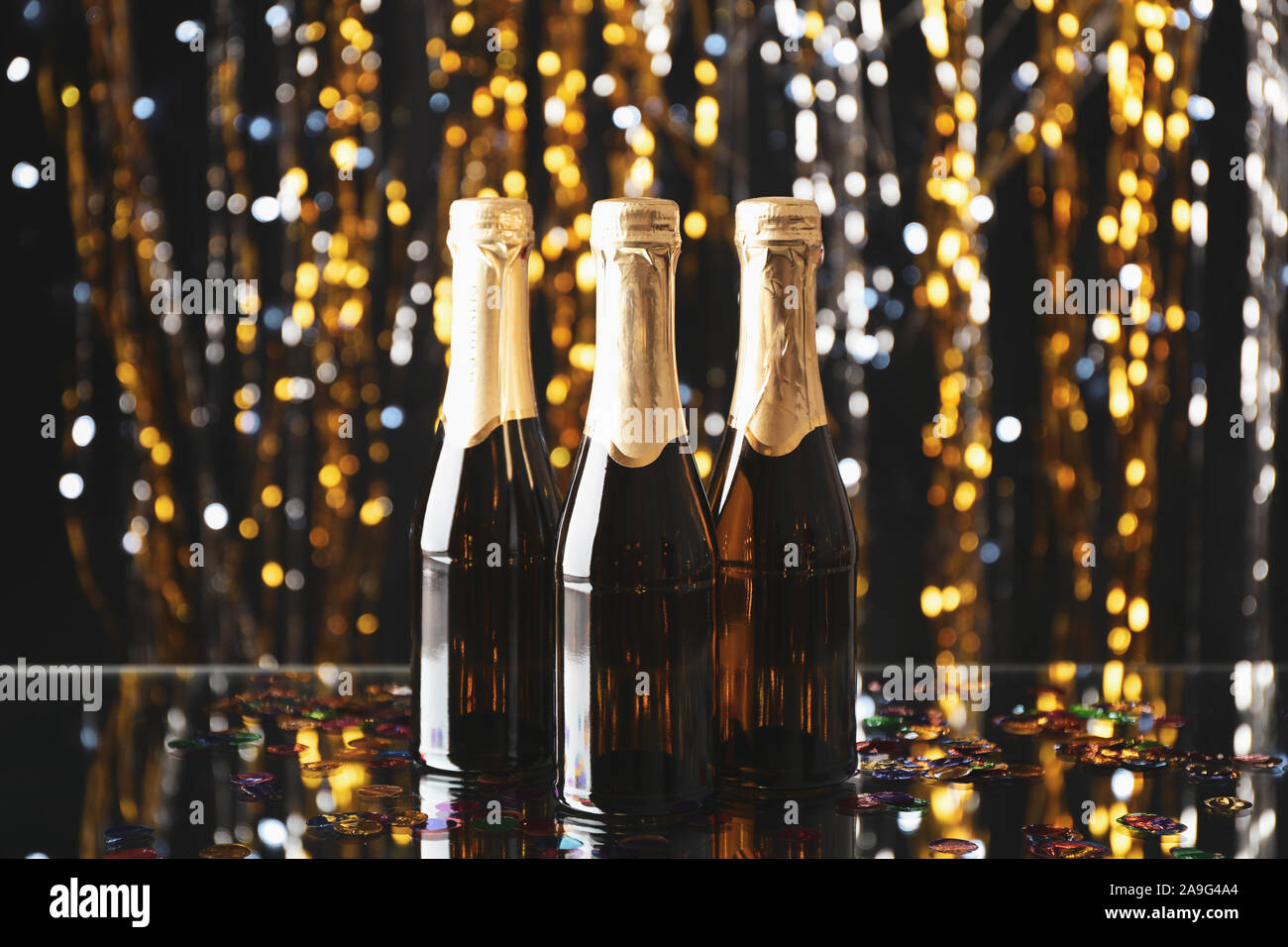 Mini champagne bottles on blurred background, space for text Stock Photo