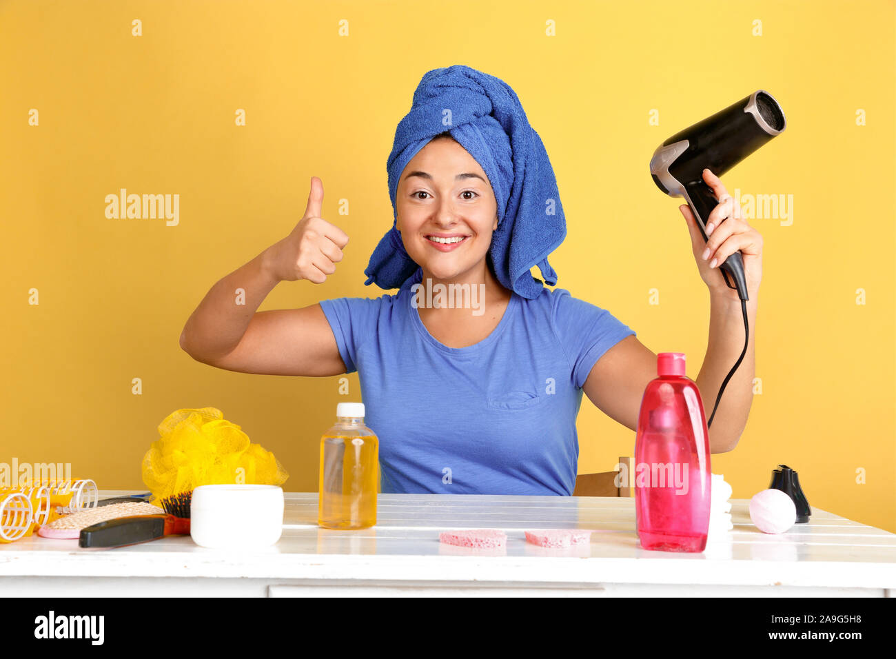 Portrait of young caucasian woman in her beauty day, skin and hair care routine. Female model with natural cosmetics applying cream and oils for make up. Body and face care, natural beauty concept. Stock Photo