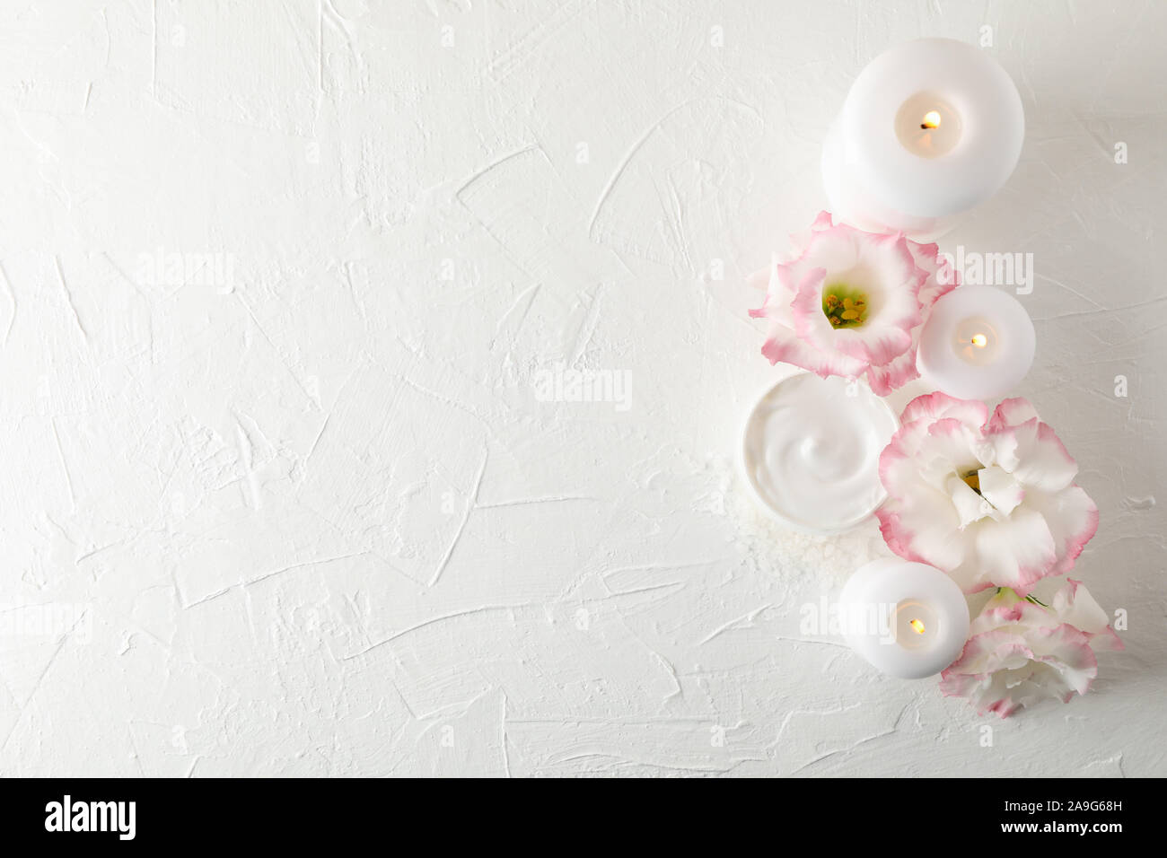 Candles, cream and flowers on white background, space for text Stock ...