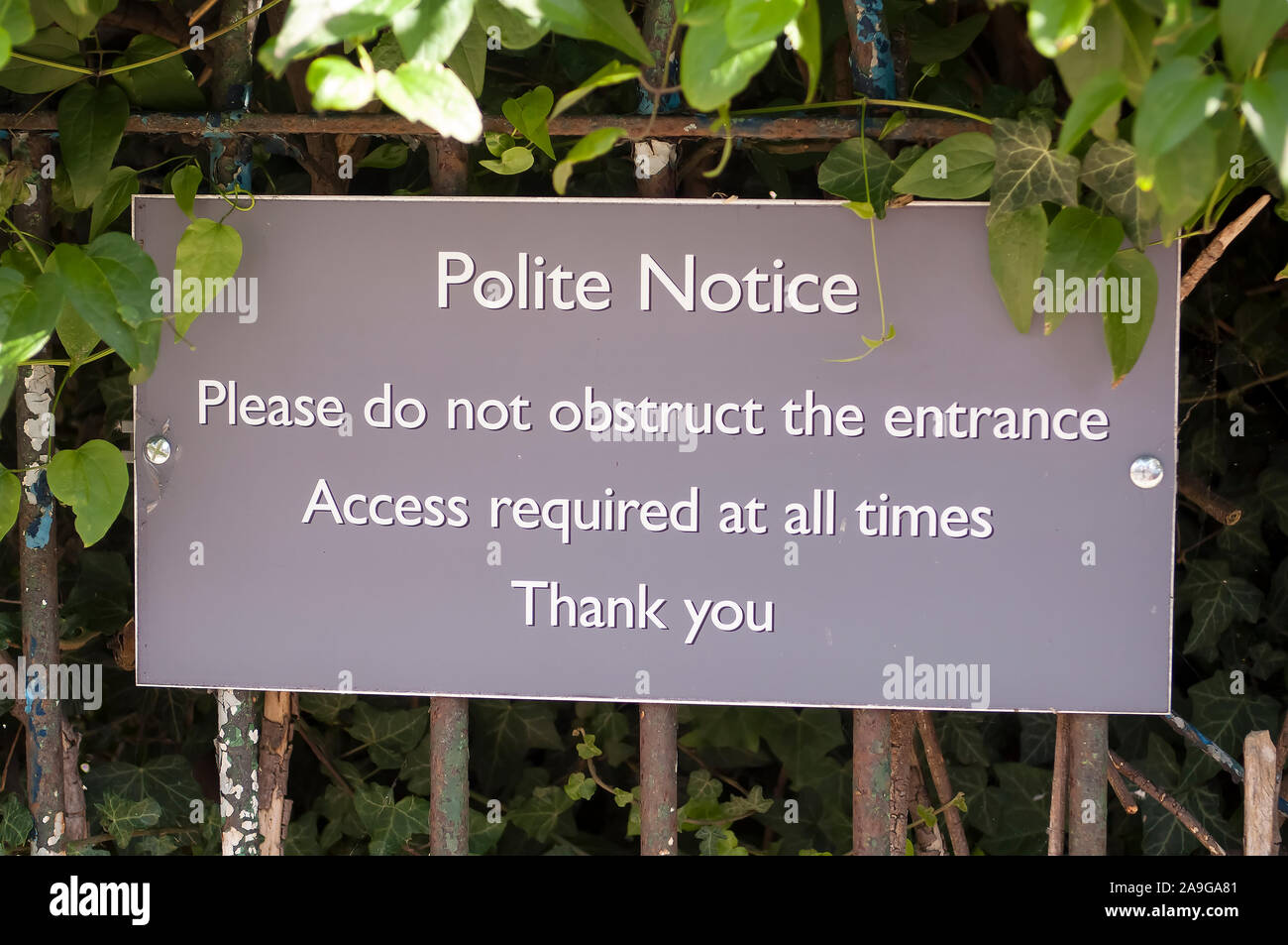 A polite notice sign asking people not to obstruct the entrance as assess is required at all times. Stock Photo