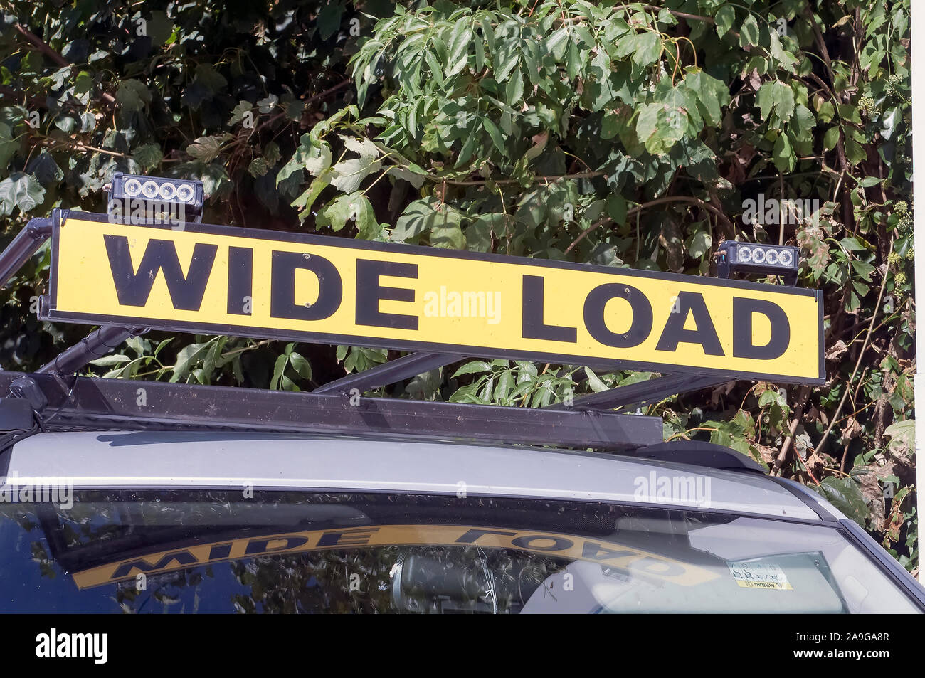 A yellow sign saying 'Wide Load'. Stock Photo