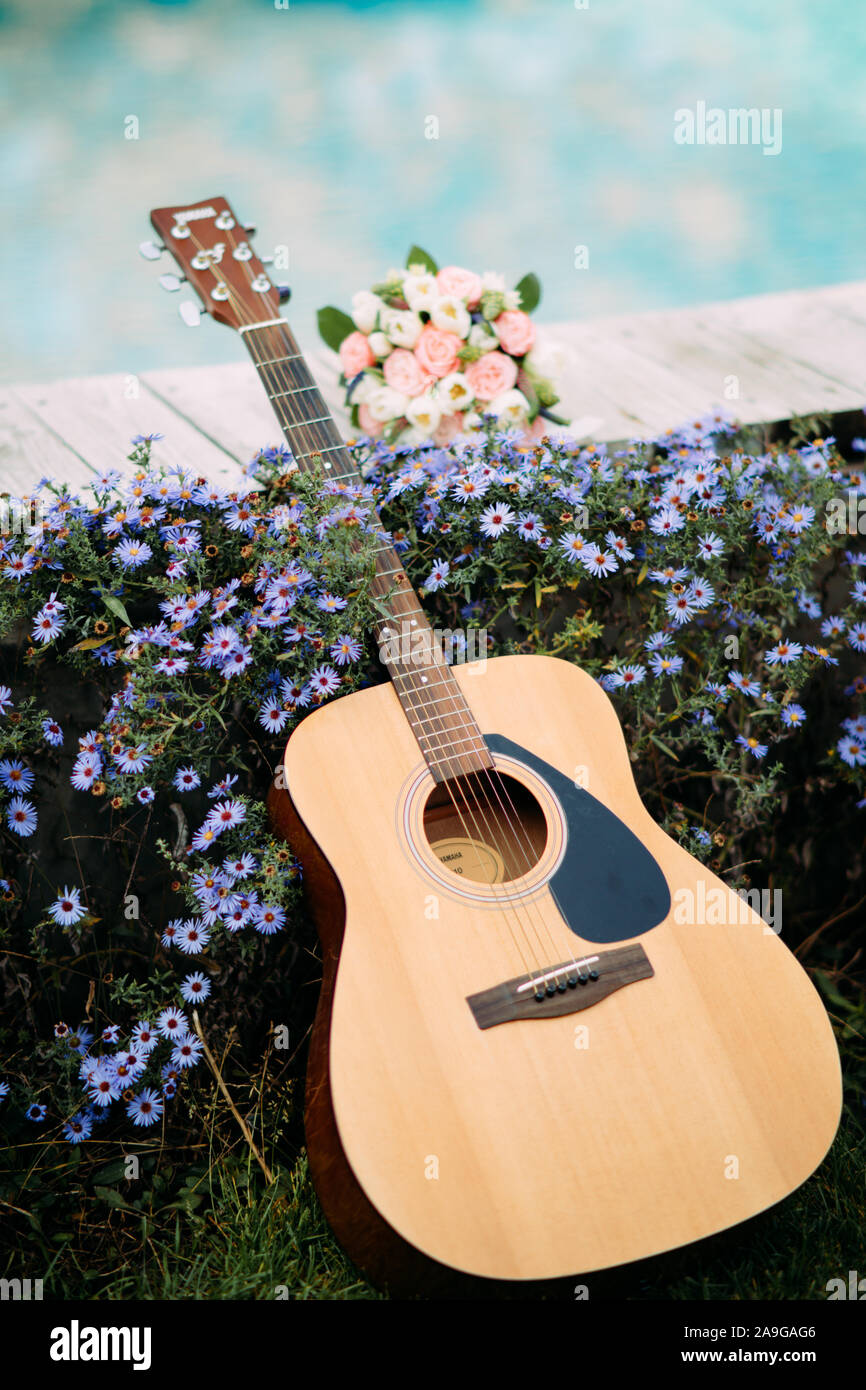 Guitar is on a background of blue flowers and a wedding bouquet of the  bride Stock Photo - Alamy