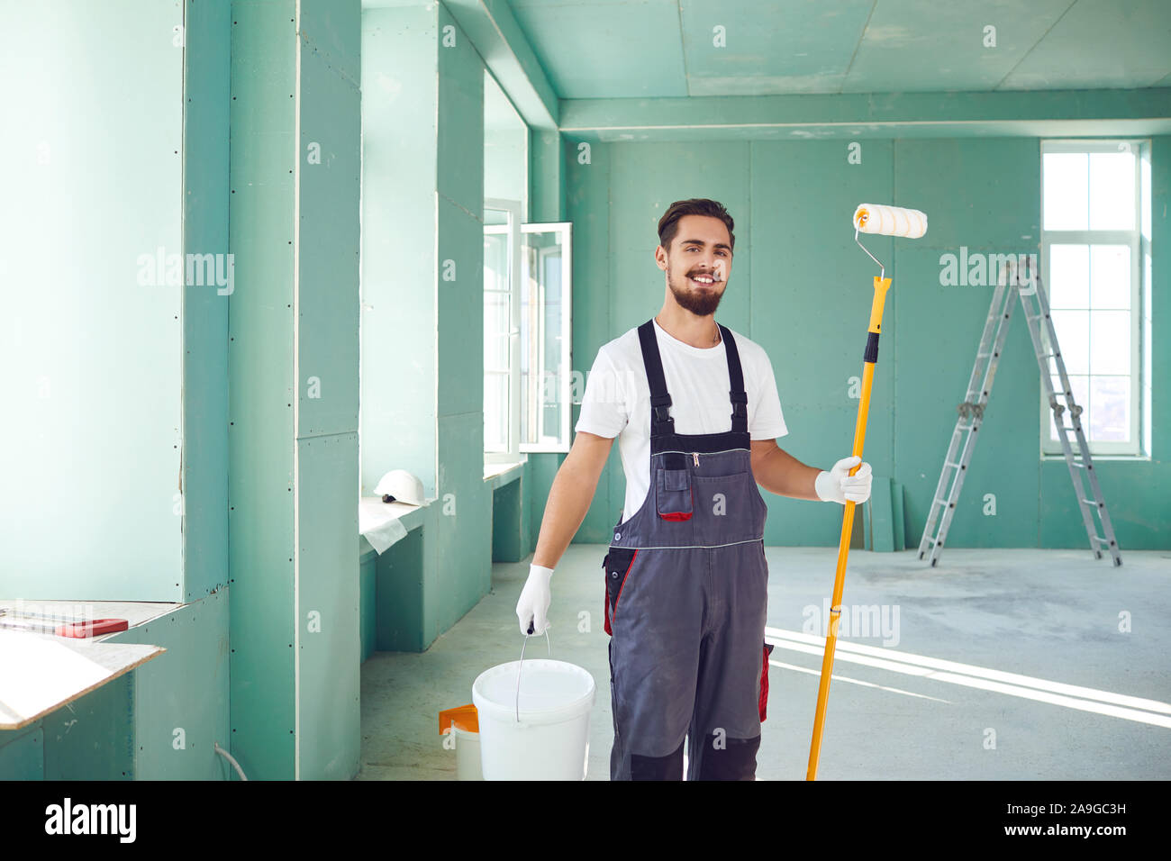 Bearded painter construction worker on a construction site. Stock Photo