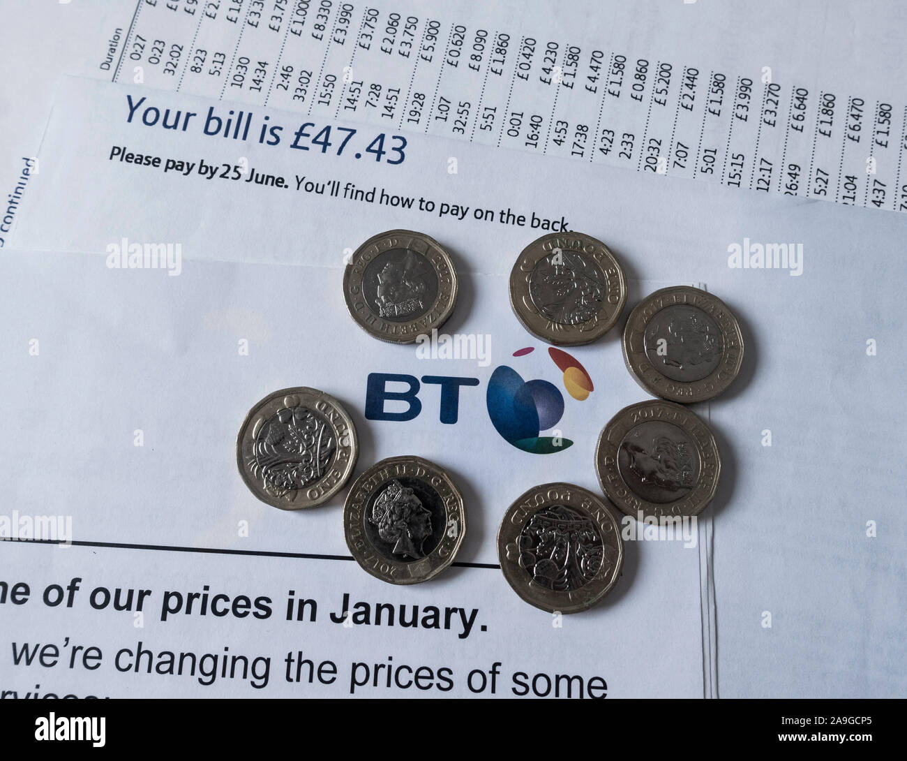 Pound coins on BT, British Telecom telephone bill. UK Stock Photo