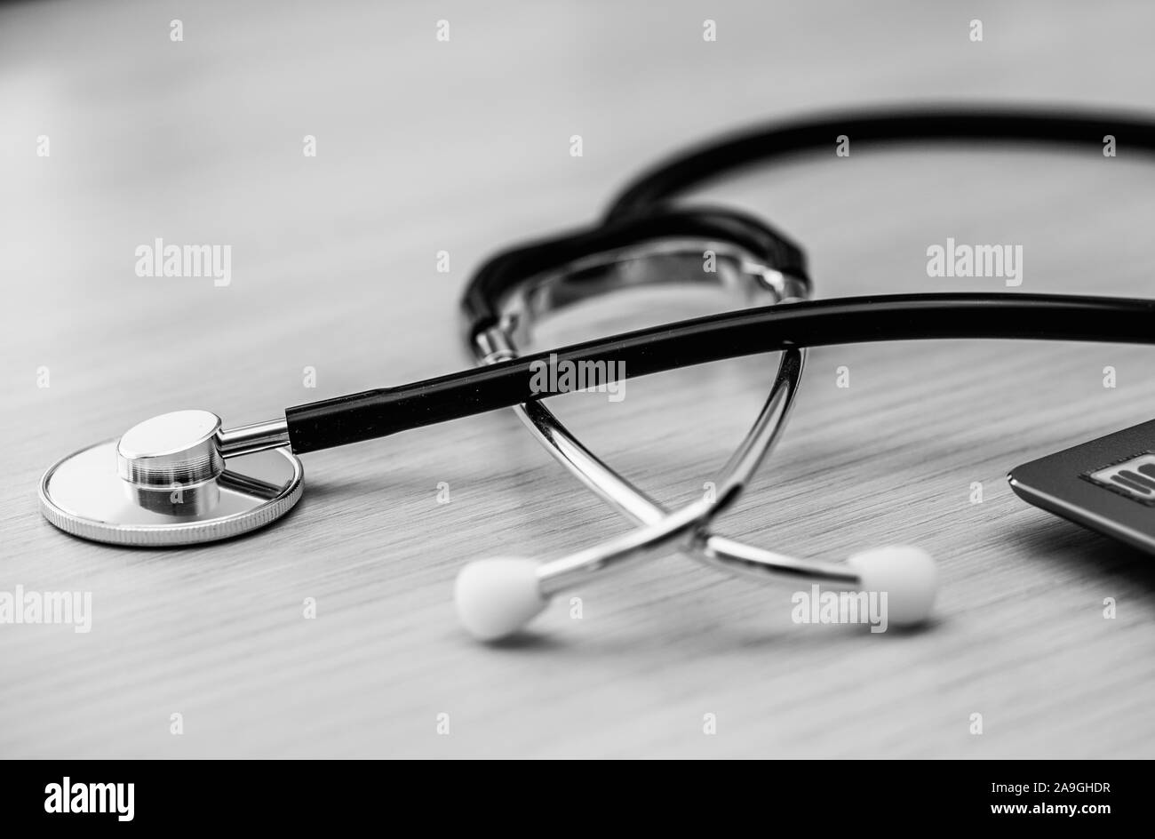 Macro black stethoscope on the table, close up view. Horizontal, black and white image Stock Photo