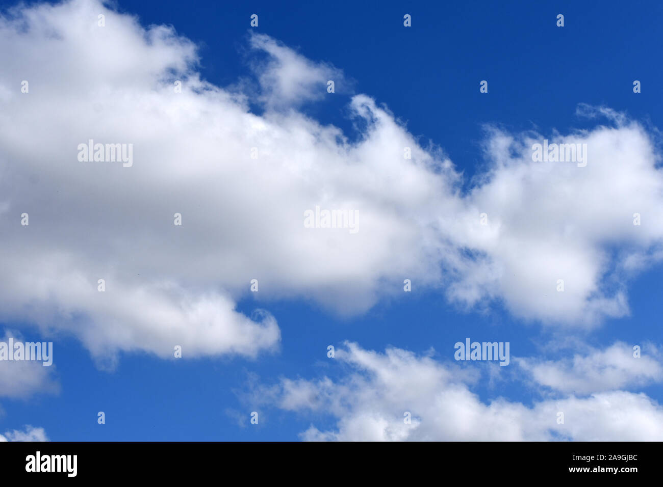 Blue sky background with white fluffy clouds Stock Photo - Alamy