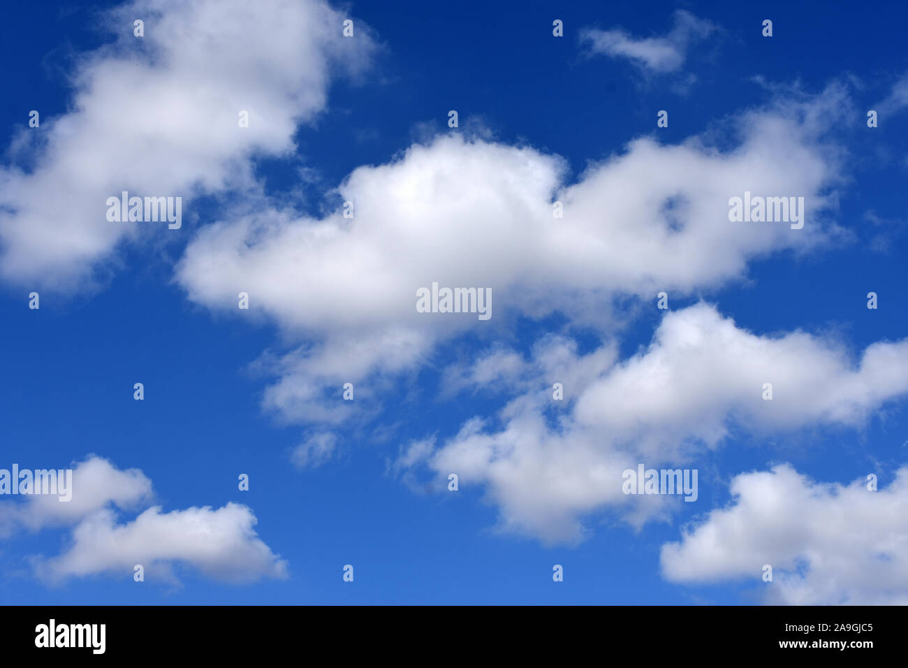 Abstract white fluffy clouds on blue sky - background Stock Photo - Alamy