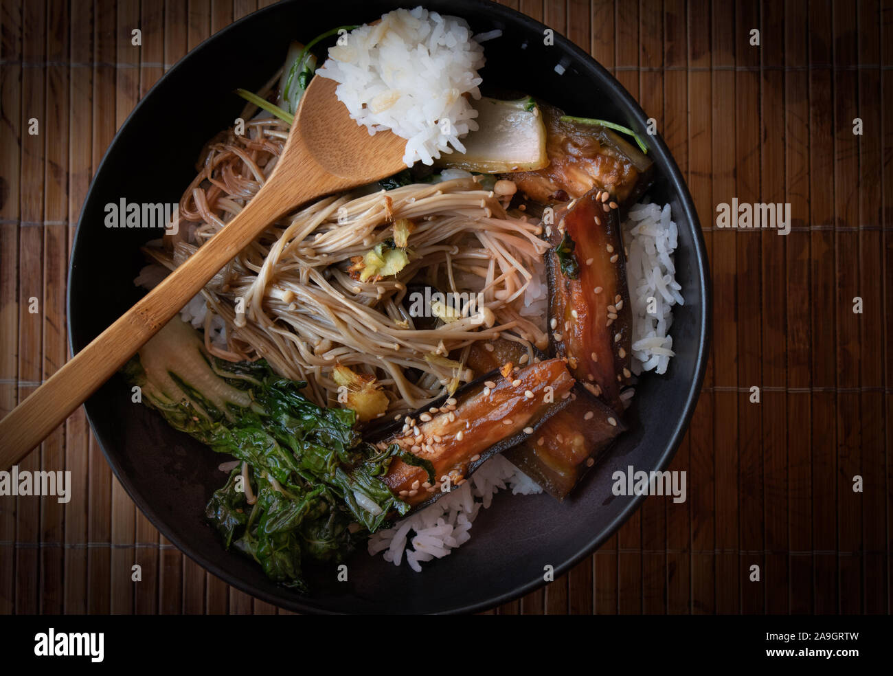 Asian egg plant, mushrooms, cabbage stir fry over rice served in black