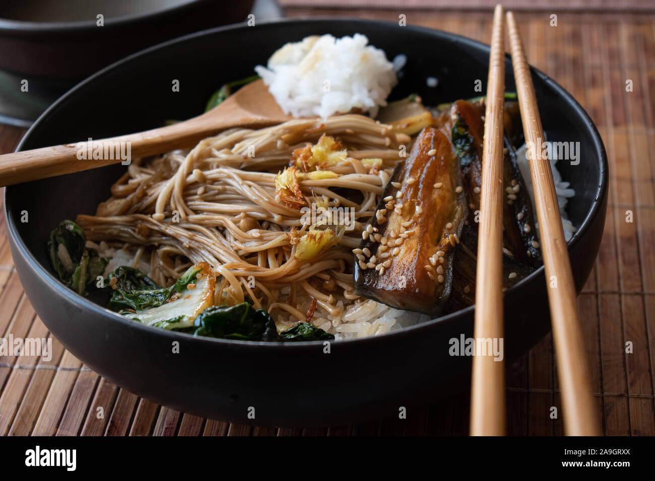 Asian egg plant, mushrooms, cabbage stir fry over rice served in black