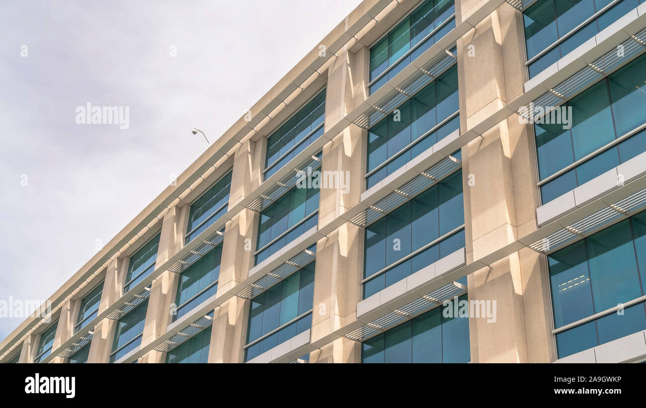 Panorama Modern building facade close up with glass windows and sunlit ...