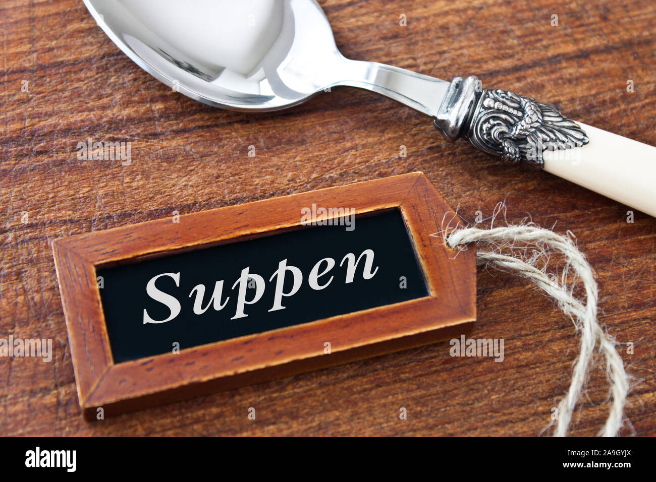 Spoon and wooden label with German: Soups Stock Photo