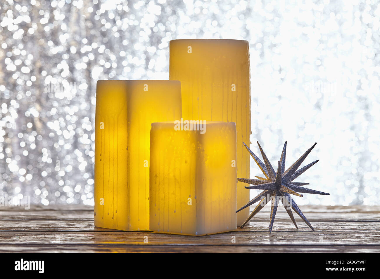 Winter holiday Christmas still life of glowing  electric square candles and star holiday ornament Stock Photo