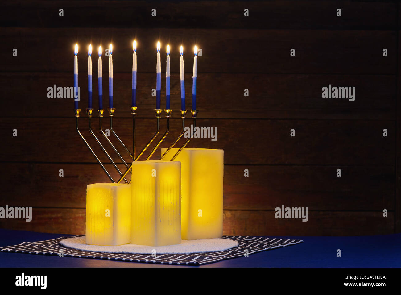 Hanukkah still life of glowing yellow electric candles and lit menorah Stock Photo