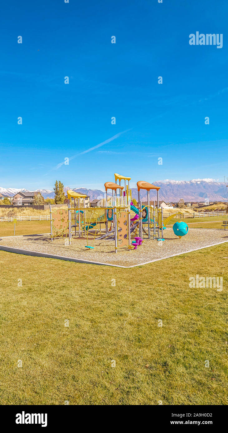Vertical frame Colorful kids playground in a grassed urban park Stock
