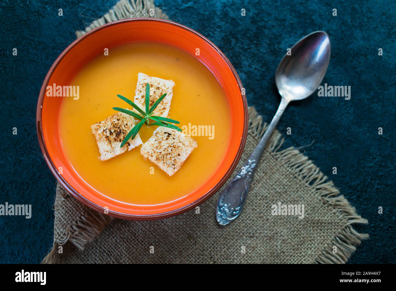 Pumpkin puree soup with garlic croutons on a black table. Top view. Stock Photo