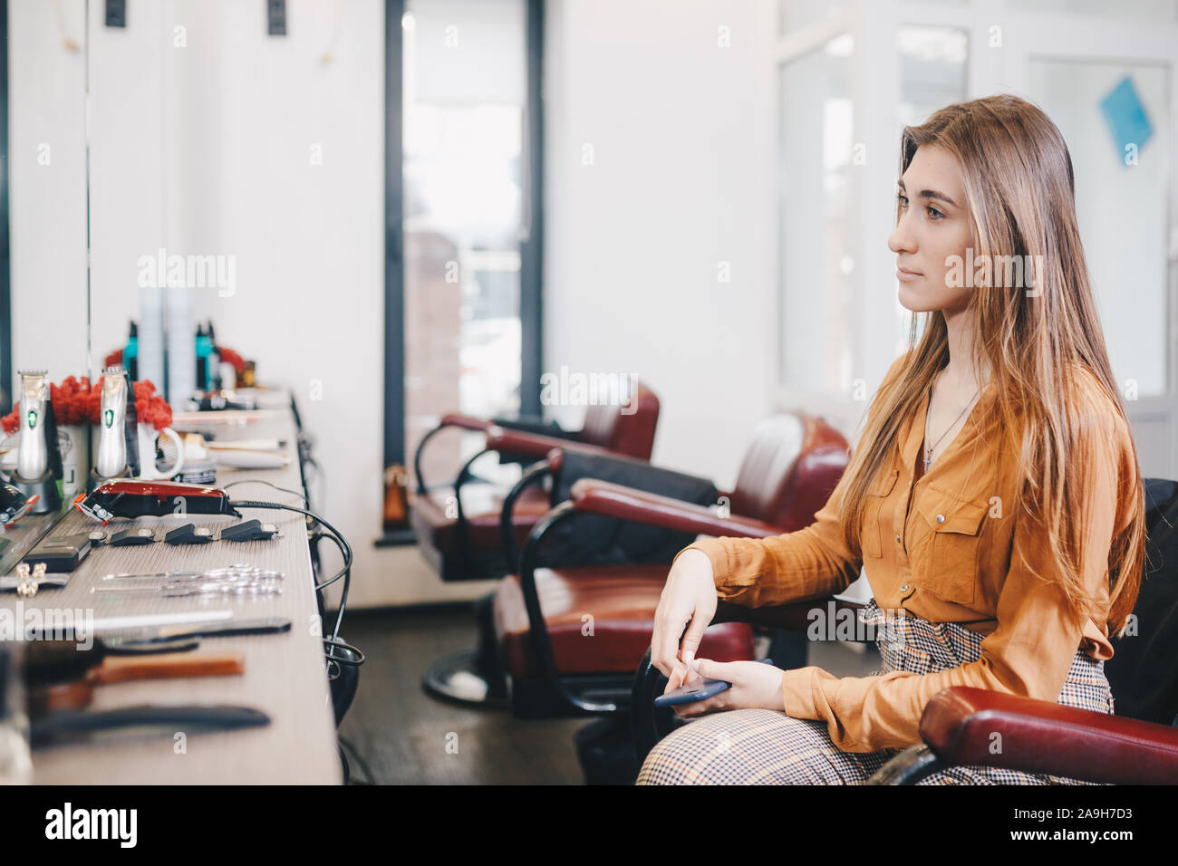 Female client in chair looking in mirror at hairdressing salon