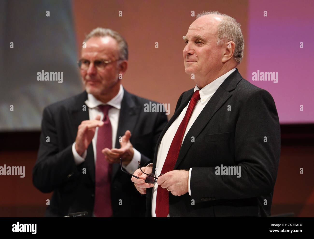 15 November 2019, Bavaria, Munich: Soccer: Bundesliga, Annual General Meeting FC Bayern Munich in the Olympiahalle. Uli Hoeneß (r), President of FC Bayern, receives applause from Karl-Heinz Rummenigge (l), Chairman of the Board of FC Bayern München AG. Photo: Tobias Hase/dpa Stock Photo