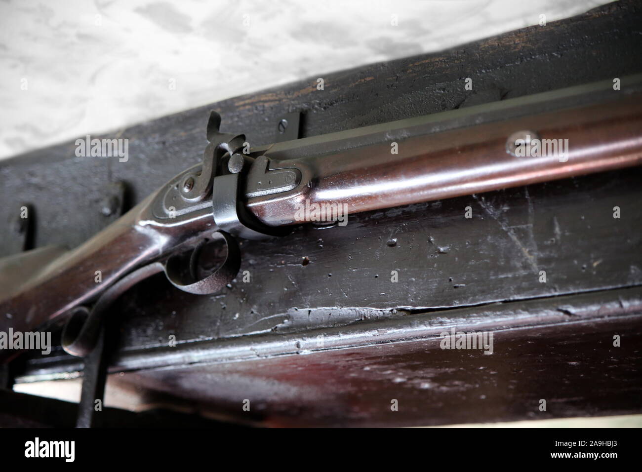 Close up detail of old flintlock rifle or musket, hanging on an old oak beam Stock Photo