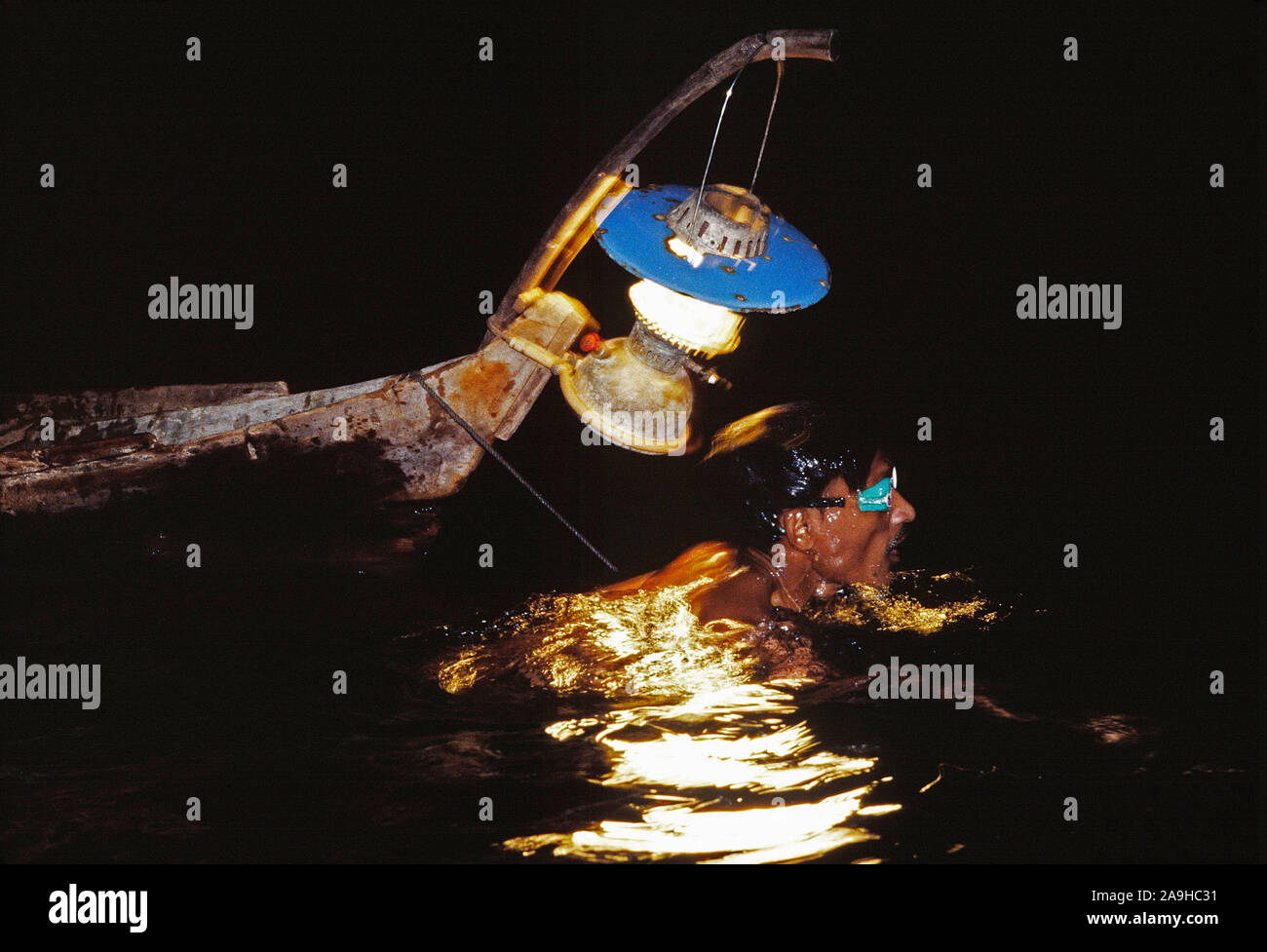 Indonesia. Sulawesi. Night view of Sama-Bajau diver in the water off Togean Island. - Stock Image