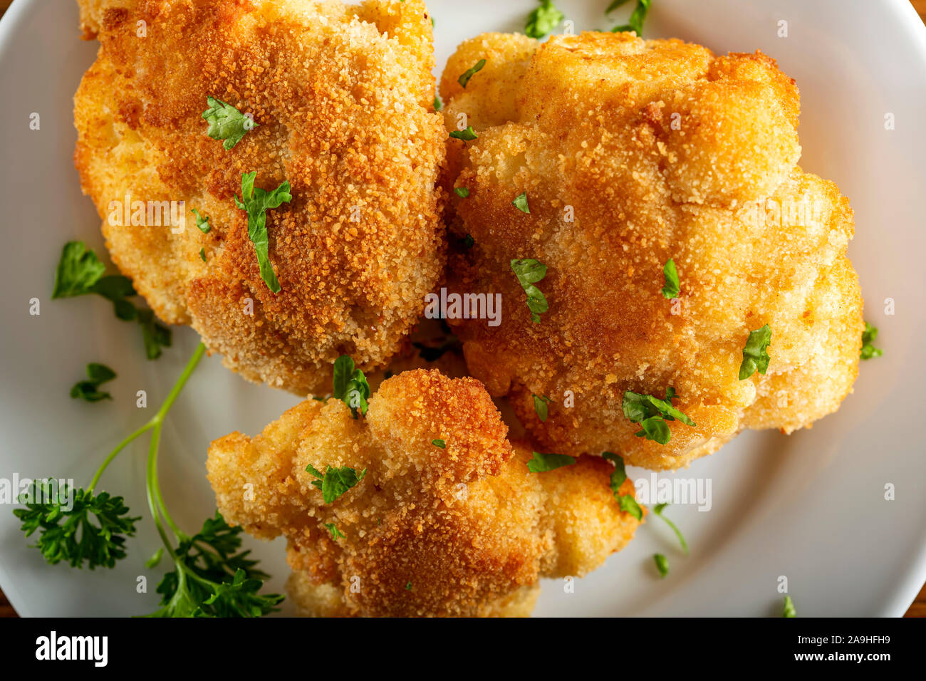 Cauliflower fried on plate with chopped parsley Stock Photo