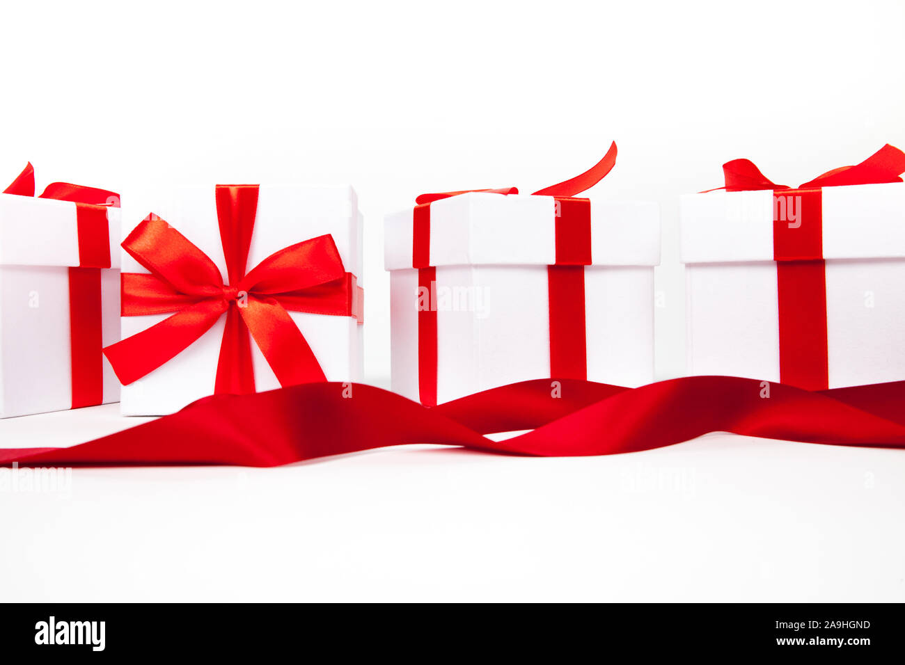 White boxes with a red satin ribbon bow Isolated on white background ...